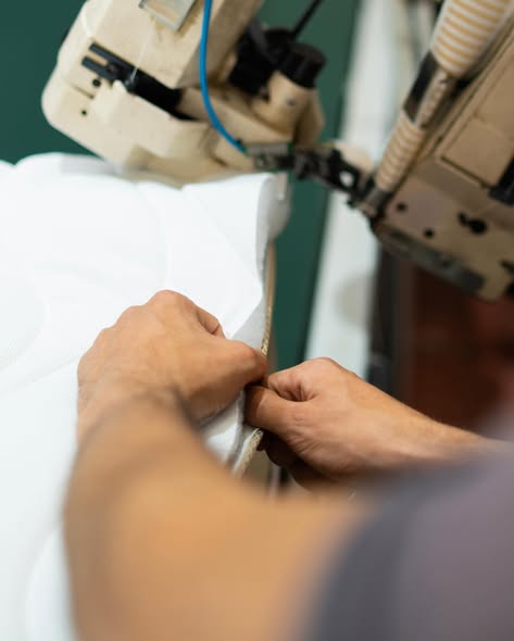 Le mani al lavoro sulla cucitura di un rivestimento Cardone